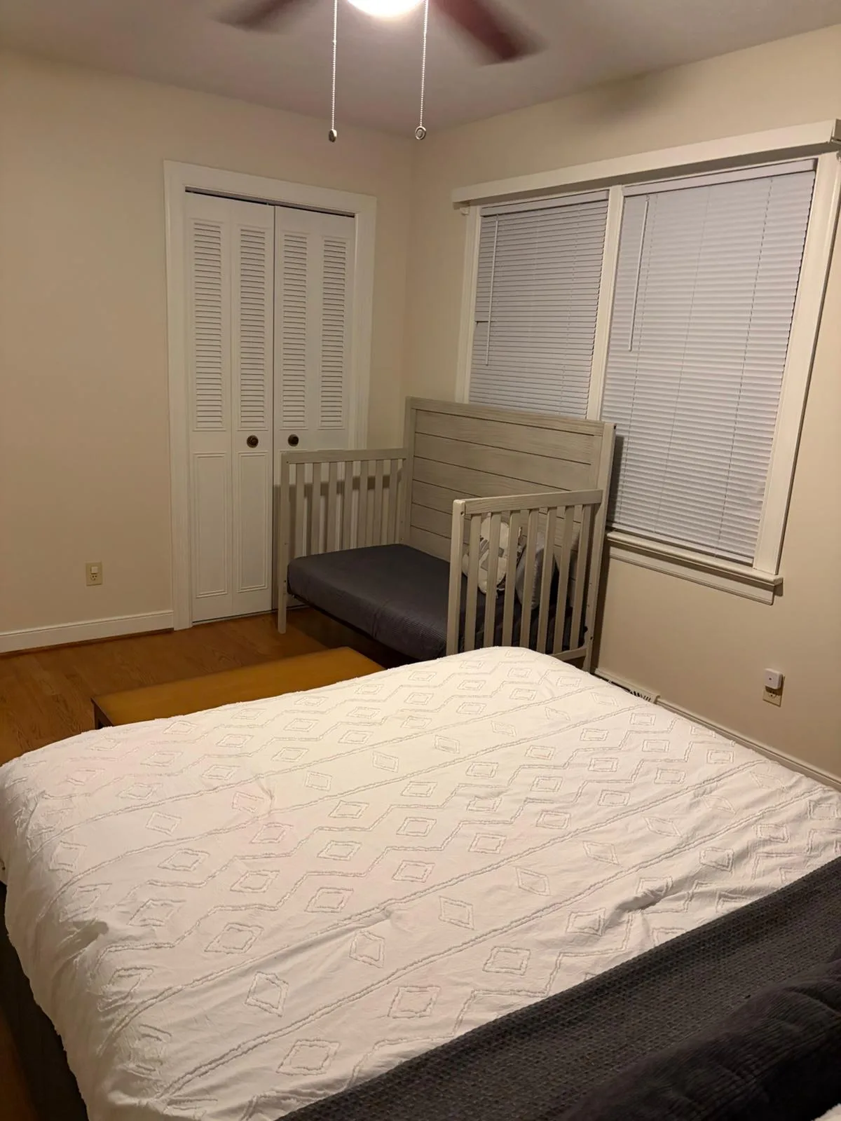 Bedroom with queen bed and crib